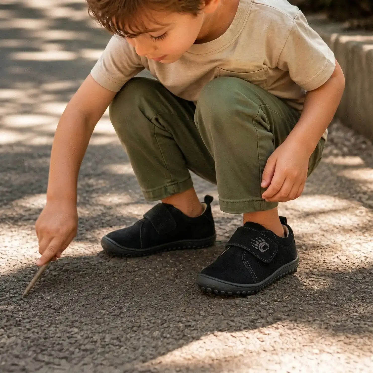 Black velcro-fastening children’s shoes with a subtle logo on the strap