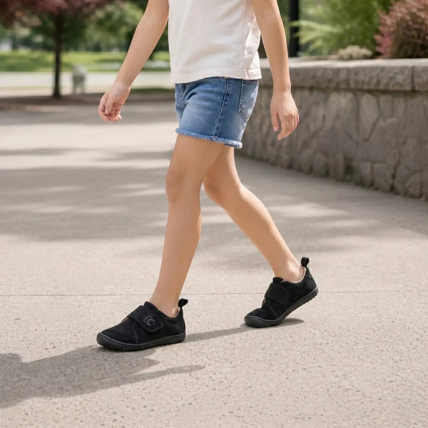 Black velcro strap slip-on shoes with a small logo on the side