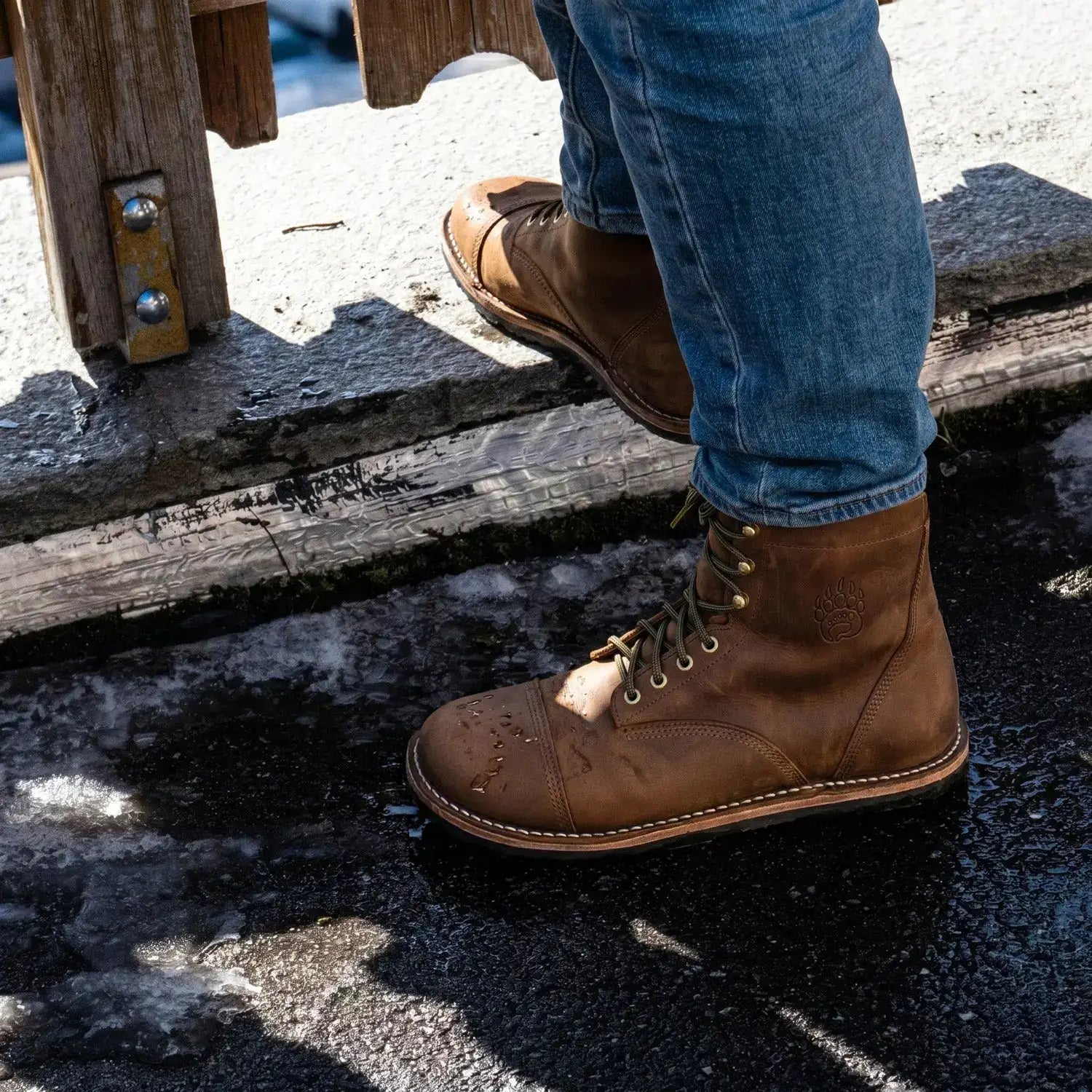 Brown leather work boot with a stitched toe cap and brass eyelets.