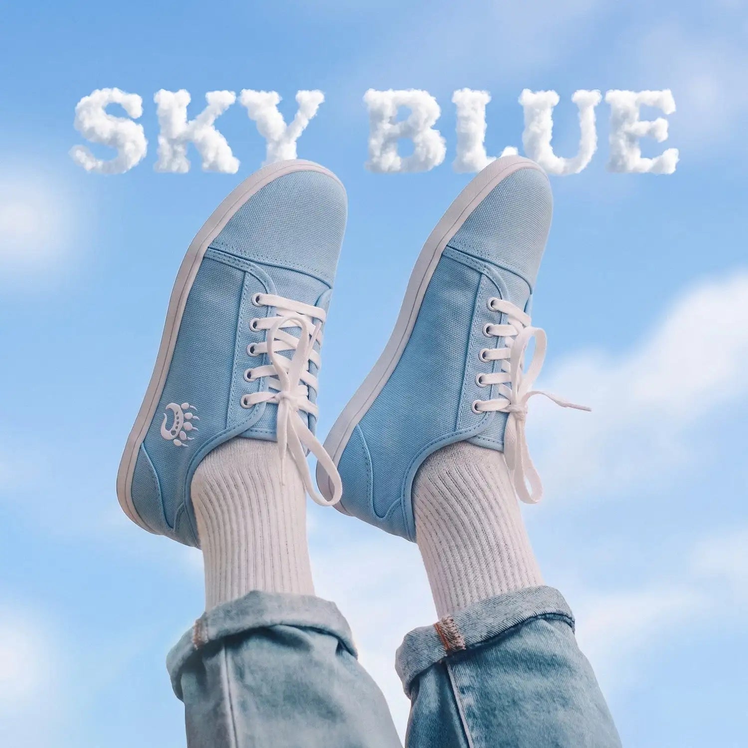 Sky blue canvas sneakers with white laces and a small embroidered logo on the side.